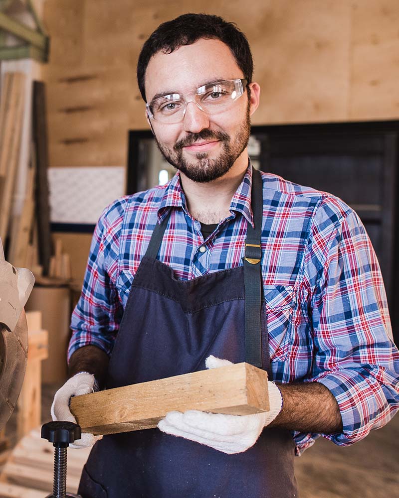 young craftsman in uniform working at carpentry an PZN4VFE